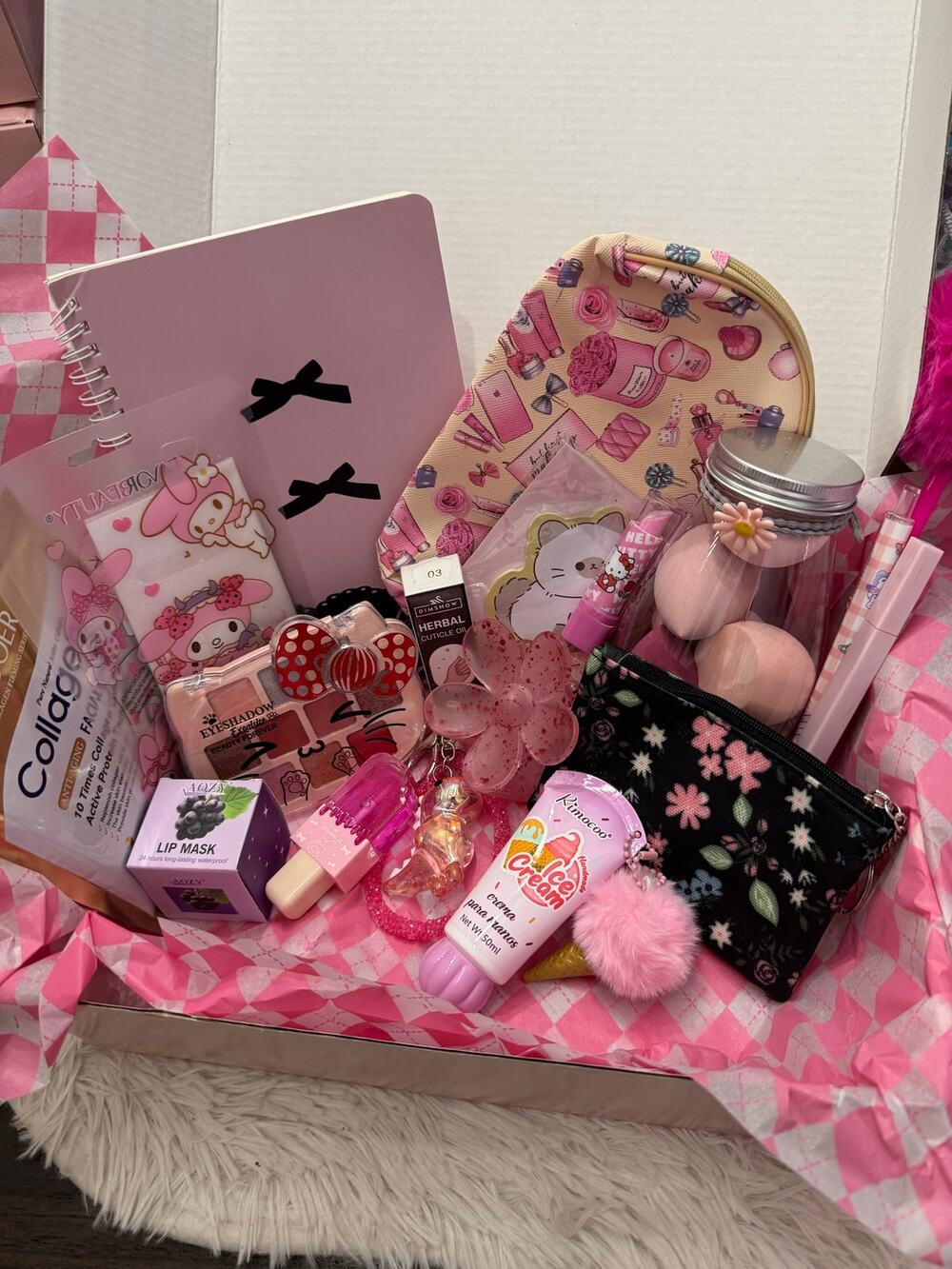 Pink gift basket with various beauty and stationery items